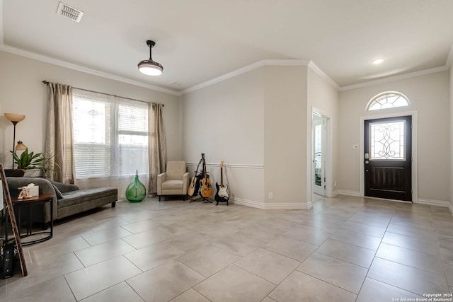 tiled entrance foyer with a healthy amount of sunlight and crown molding