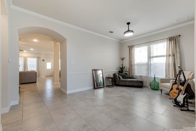 sitting room with crown molding and light tile patterned floors