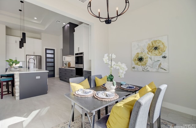 dining space featuring an inviting chandelier, a high ceiling, and a raised ceiling