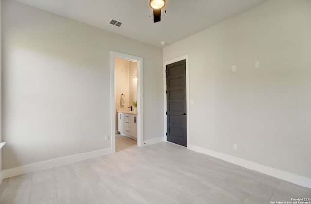 unfurnished bedroom featuring ceiling fan and ensuite bathroom