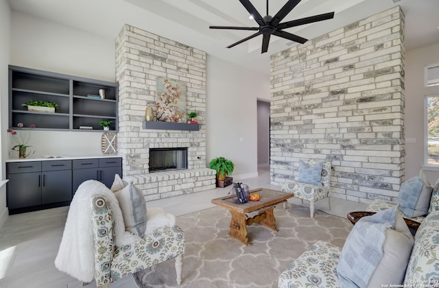 living room with ceiling fan and a fireplace