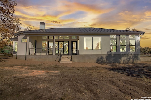 back house at dusk with a porch