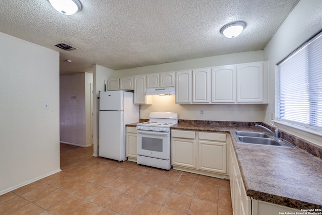 kitchen with white appliances, a textured ceiling, white cabinetry, and sink