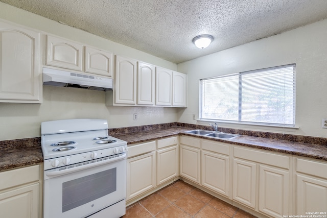 kitchen with a textured ceiling, sink, white cabinetry, light tile patterned floors, and white range with electric stovetop