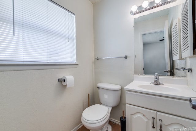 bathroom with a textured ceiling, vanity, and toilet