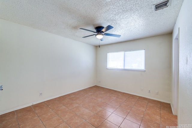 tiled empty room featuring a textured ceiling and ceiling fan