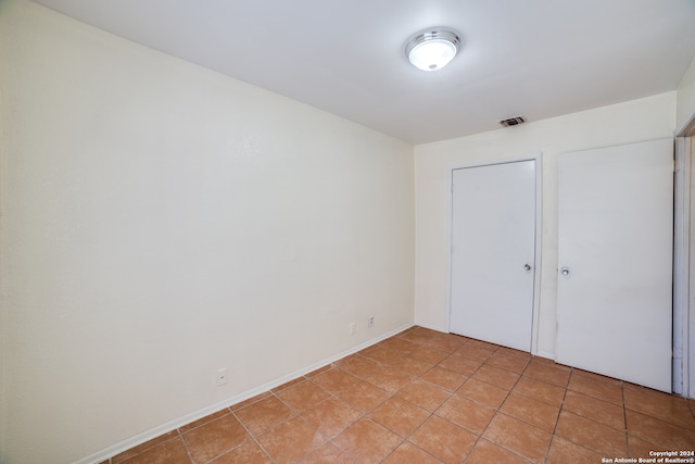 unfurnished bedroom featuring light tile patterned flooring and a closet