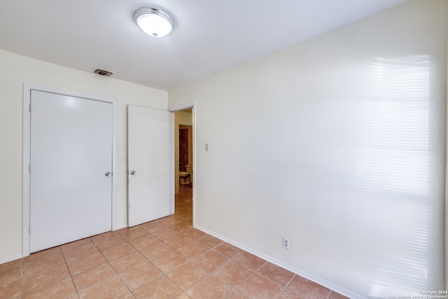 unfurnished bedroom with a closet and light tile patterned floors