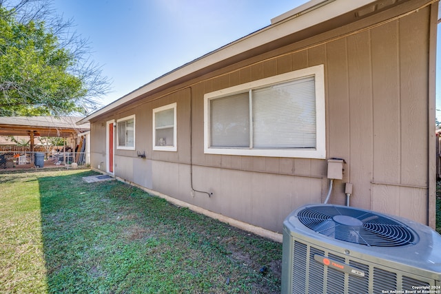 view of property exterior featuring cooling unit and a yard