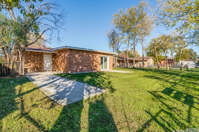 rear view of property with a lawn and a patio area