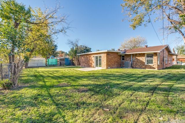 back of house with a shed, a yard, central AC, and a patio area