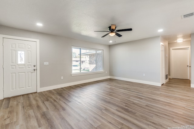 foyer entrance featuring a textured ceiling, light hardwood / wood-style floors, and ceiling fan