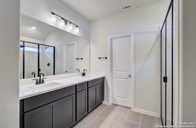 bathroom with vanity and a shower with door