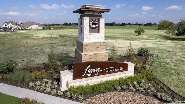 community sign featuring a yard and a rural view