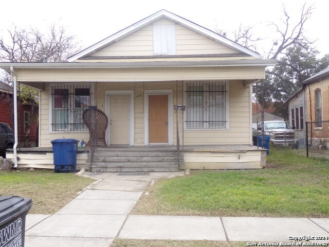 bungalow with a front lawn and covered porch