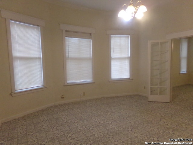 unfurnished room featuring an inviting chandelier