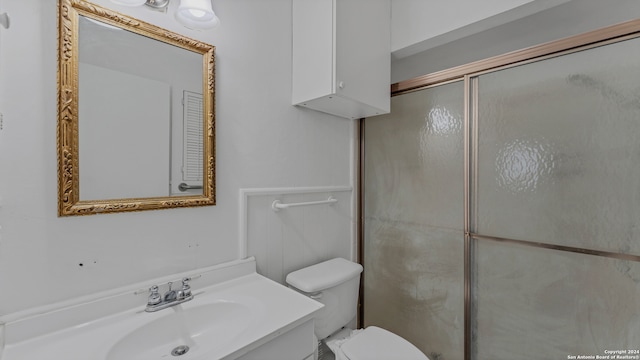 bathroom featuring walk in shower, vanity, and toilet