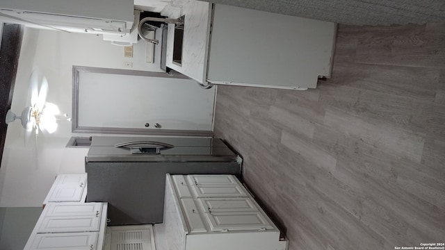 kitchen with white cabinets and tile walls