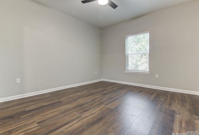 empty room with dark wood-type flooring, baseboards, and ceiling fan