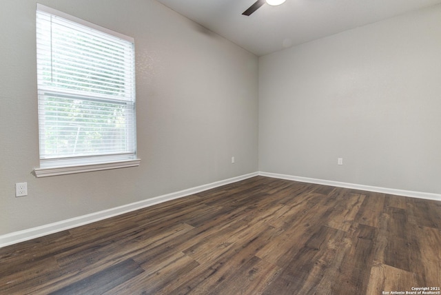 empty room with baseboards, dark wood-style flooring, and a ceiling fan