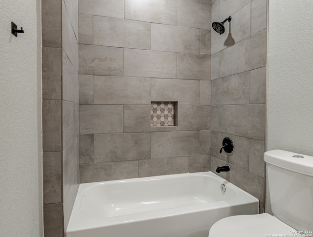 bathroom with tiled shower / bath and toilet