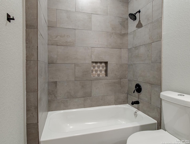 bathroom featuring toilet and a textured wall