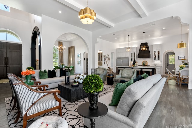 living room with beamed ceiling, dark hardwood / wood-style floors, and a chandelier