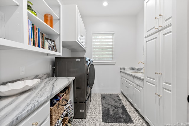 washroom featuring cabinets, independent washer and dryer, and sink