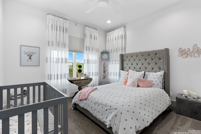 bedroom with ceiling fan and dark carpet