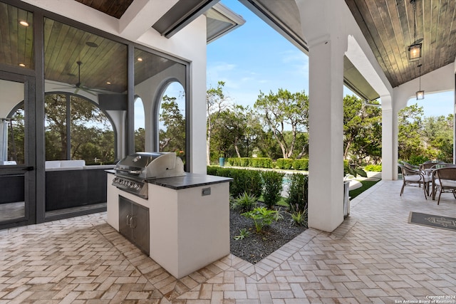 view of patio / terrace with a grill, ceiling fan, and exterior kitchen