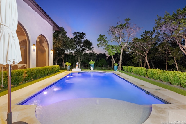 pool at dusk featuring a patio area