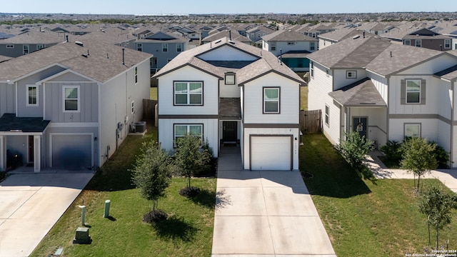 view of front of property with a garage, central AC, and a front lawn