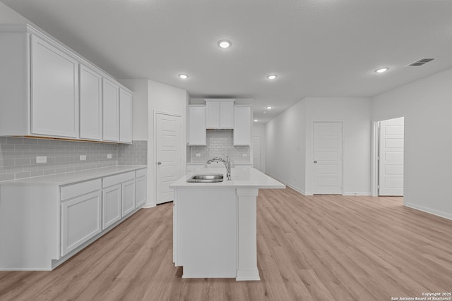 8432 Roadrunner Psge, San Antonio, TX 78222 - kitchen with tasteful backsplash, light countertops, light wood finished floors, a sink, and visible vents
