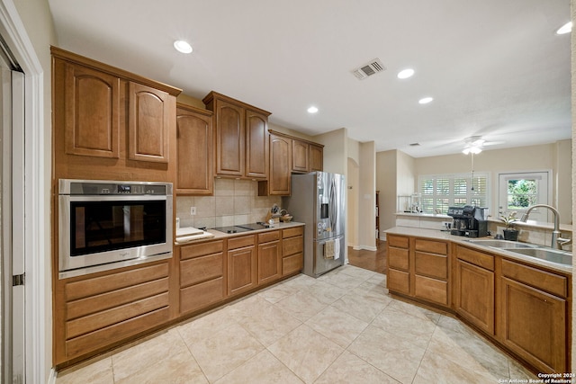 kitchen featuring tasteful backsplash, sink, appliances with stainless steel finishes, light tile patterned floors, and ceiling fan