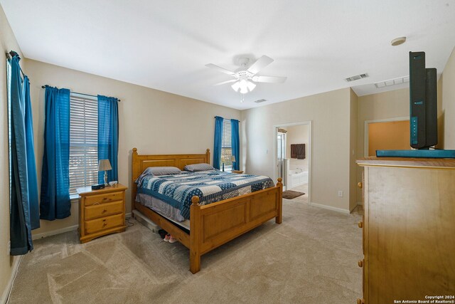 carpeted bedroom featuring ensuite bath and ceiling fan