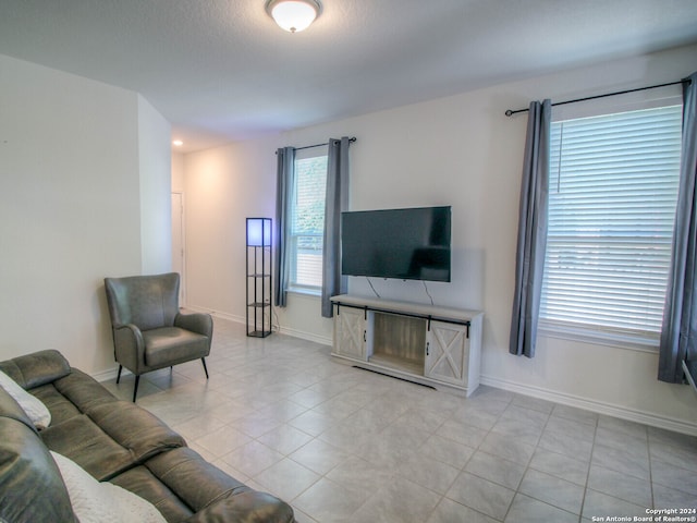 living room featuring a textured ceiling and light tile patterned flooring