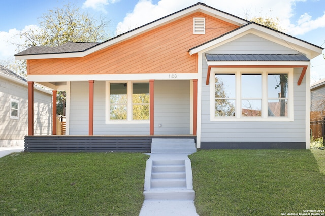 view of front of property featuring covered porch and a front yard