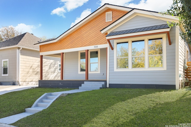 view of front of property featuring covered porch and a front yard