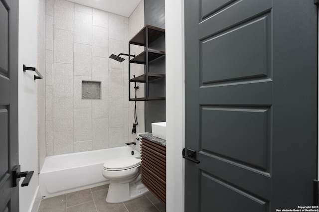 full bathroom featuring toilet, vanity, tiled shower / bath combo, and tile patterned flooring