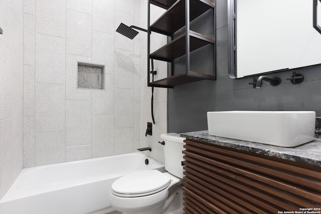 full bathroom with toilet, vanity, and tiled shower / bath combo