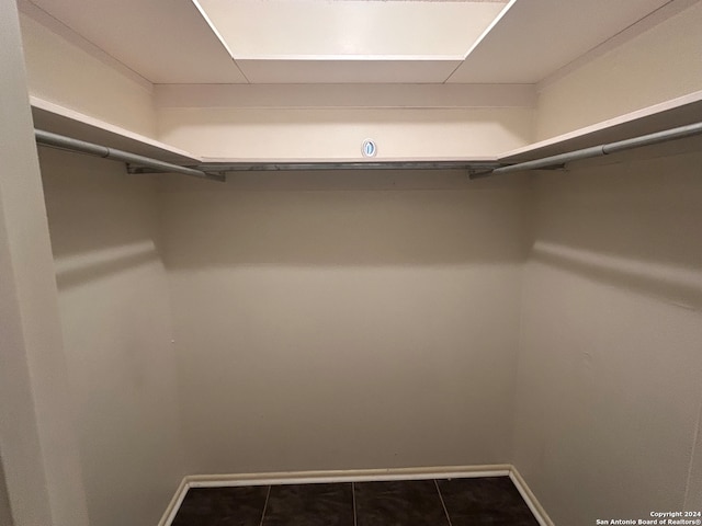 spacious closet featuring dark tile patterned floors