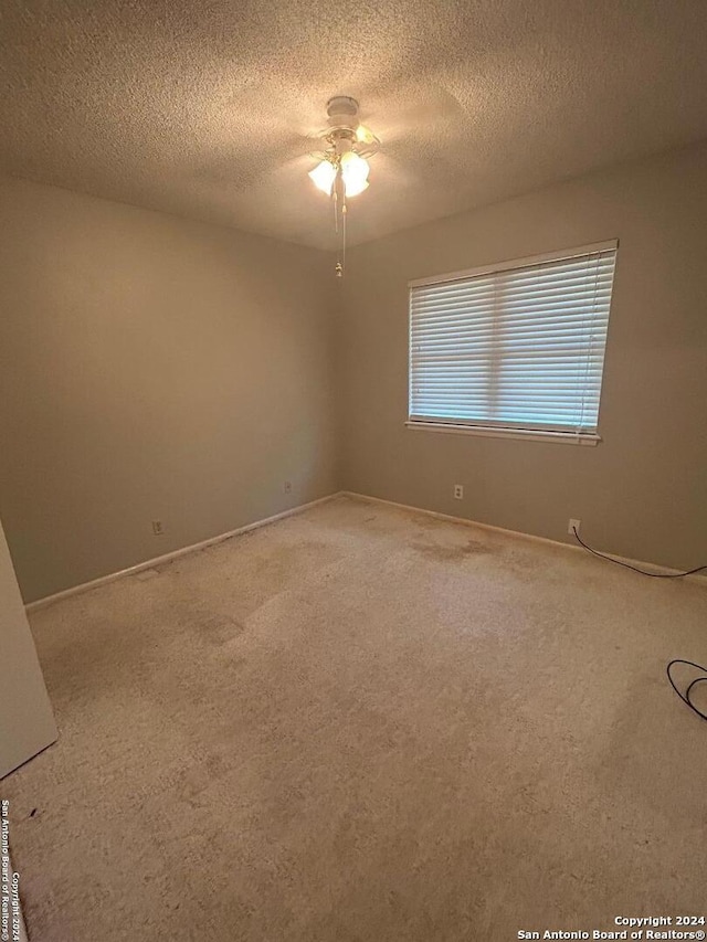 carpeted empty room with a textured ceiling and ceiling fan