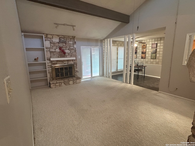 unfurnished living room with dark carpet, a fireplace, and lofted ceiling with beams