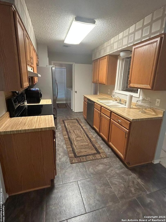 kitchen with a textured ceiling, stove, sink, and stainless steel dishwasher