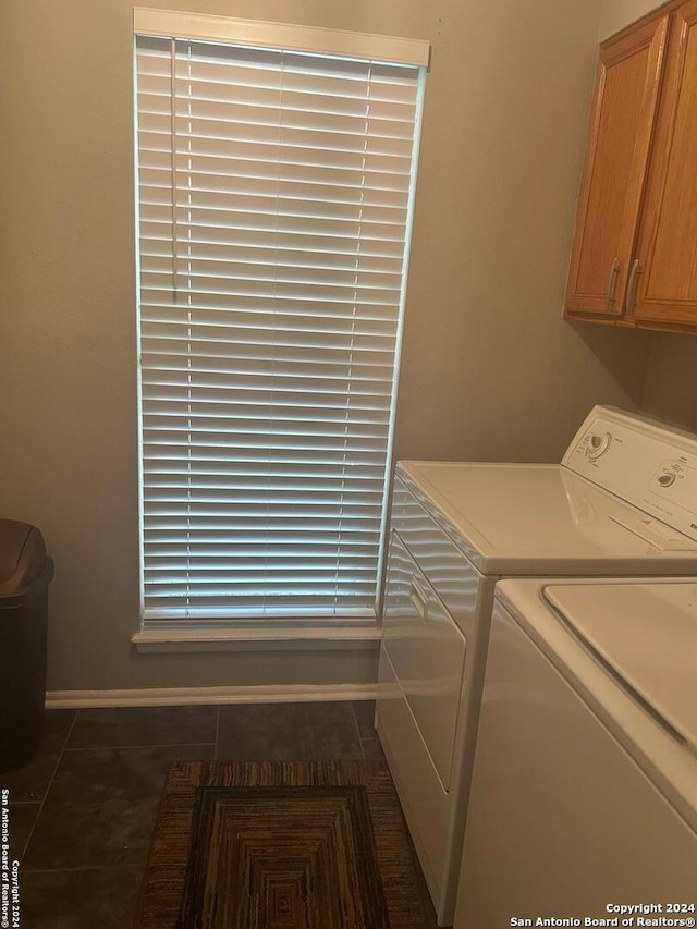 laundry area with separate washer and dryer, cabinets, and dark tile patterned flooring