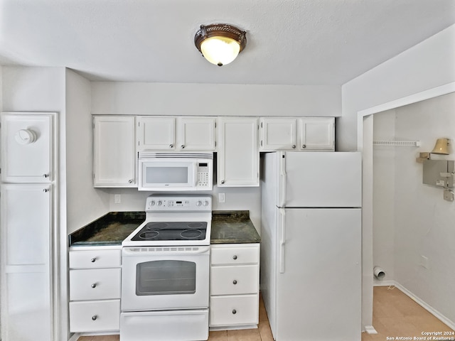 kitchen featuring white appliances, white cabinetry, and light tile patterned floors