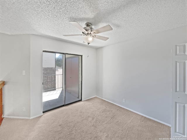 carpeted empty room featuring a textured ceiling and ceiling fan