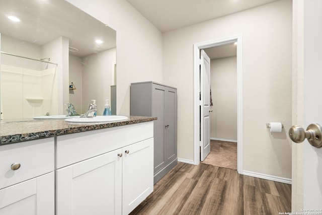 bathroom featuring hardwood / wood-style floors, walk in shower, and vanity