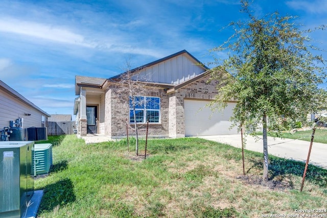 view of front of home featuring a garage, central AC, and a front lawn