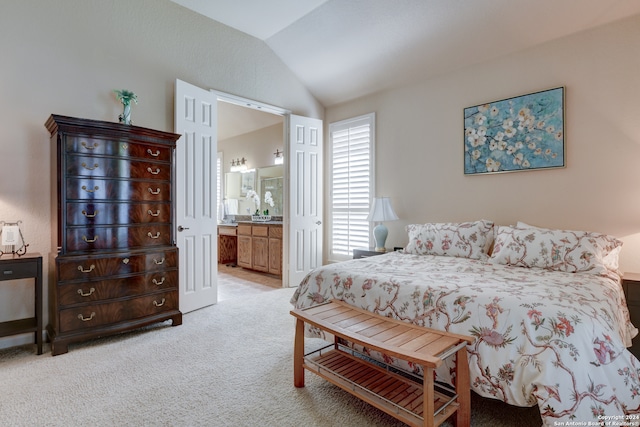 bedroom featuring light carpet, vaulted ceiling, and connected bathroom